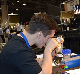 A contestant closely examining one of the coins during the PCGS Coin Grading Contest at the June 2015 Long Beach Expo.
