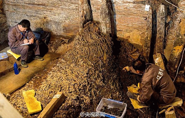 Researchers sift through huge piles of the copper coins. Source: ecns.cn