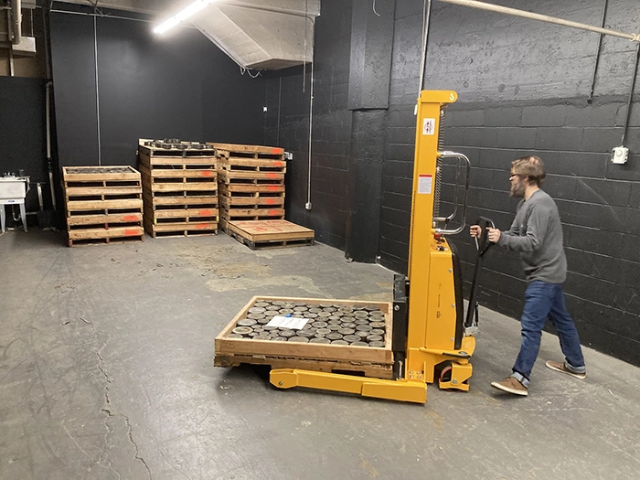 Figure 4. Jesse uses the pallet-stacker to position pallets from the first truck load. Image: American Numismatic Society.