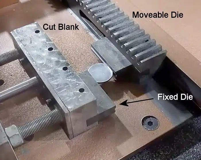 Figure 2. As the gear was turned by a hand crank, the moveable die pressed the blank against the other thereby forcing the blank into lettering or ornamental design either raised or incuse on the dies. The machine had travel stops so the blank completed exactly one-half a rotation, thus imprinting the full planchet diameter.