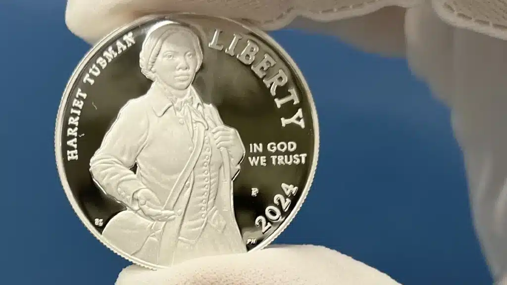 A mint employee holds up the first Harriet Tubman commemorative dollar. Image: U.S. Mint.