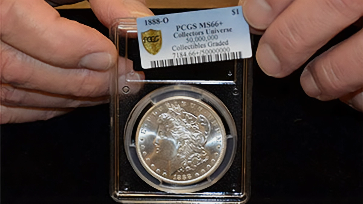In 2014, former PCGS President Don Willis was photographed placing an insert into PCGS holder to mark the 50 millionth item graded by the company. Image: PCGS.
