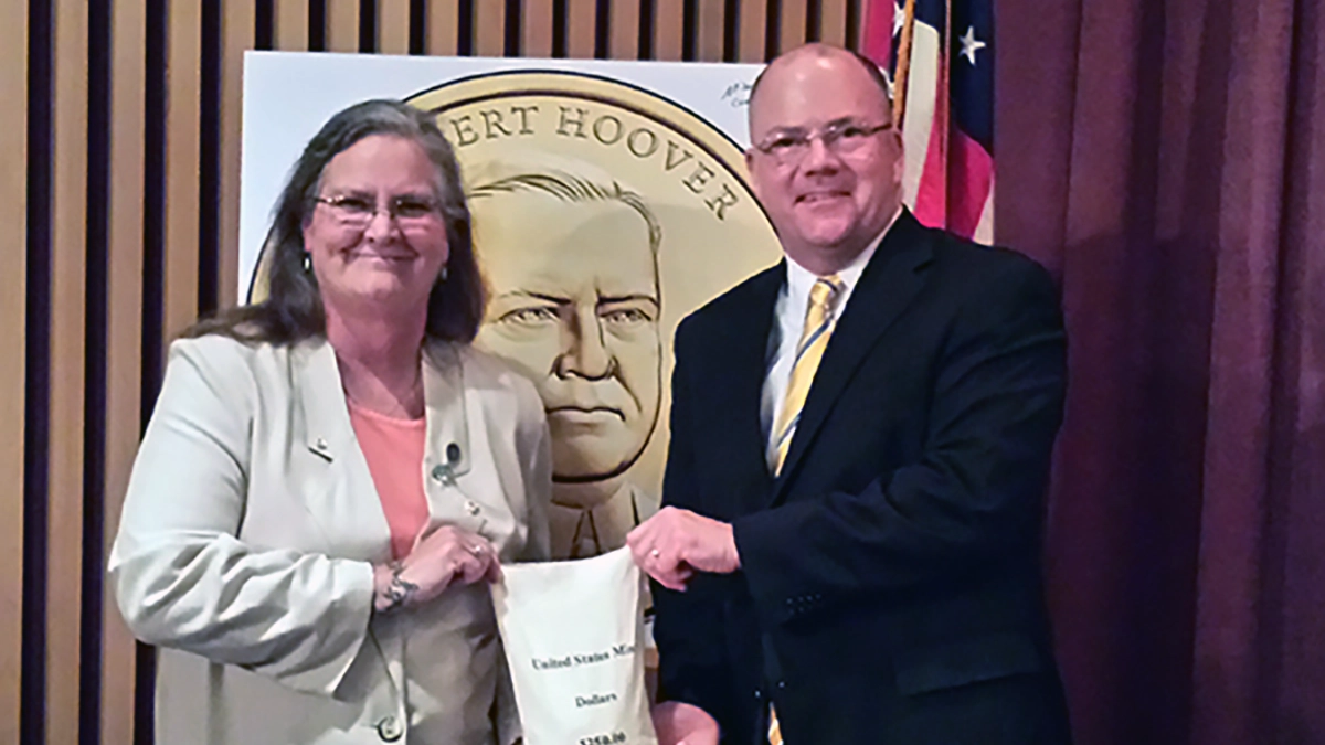 Leslie Hoover-Lauble and Michael A. Olson hold a $250 bag of 2014 Herbert Hoover Presidential Dollars.