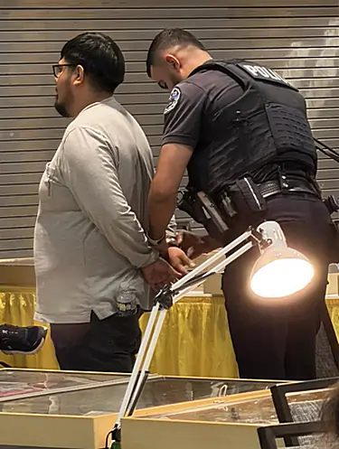 Schaumburg police arresting one of the two suspects on the Bourse Floor