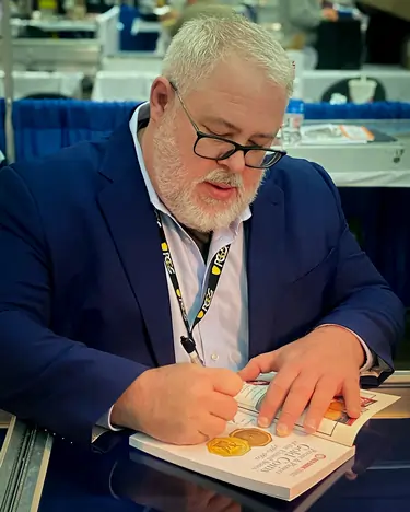 Whitman author David McCarthy signing recet release A Guide Book of Private & Pioneer Gold Coins.Image courtesy: Whitman Brands.
