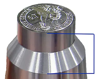 Quenching a red-hot die for hardening. The die sits on a metal plate with its face extending through a hole. The “J”-shaped tube directs water against the face, while the protected body cools more slowly. Workers then immersed the entire die in water. Adam Eckfeldt originally used this general arrangement circa 1797.